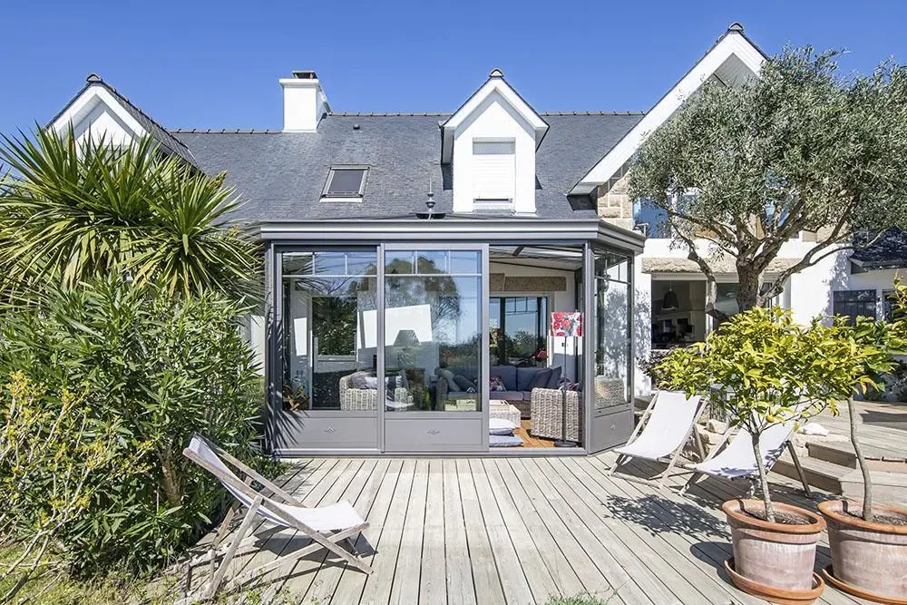 Extension de maison moderne avec véranda fermée à toiture plate, bardage aluminium anthracite RAL 7016