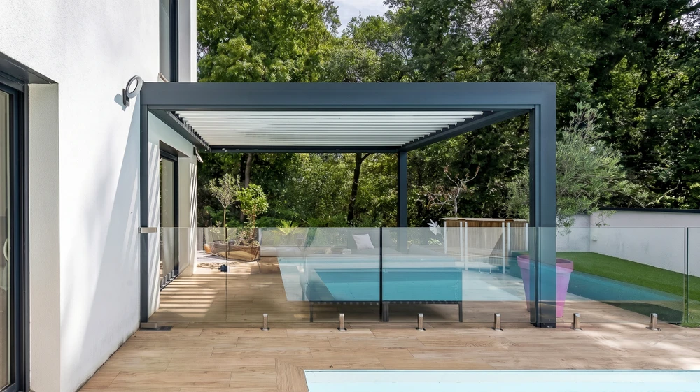 Terrasse couverte moderne avec pergola bioclimatique à lames orientables blanches, structure aluminium anthracite