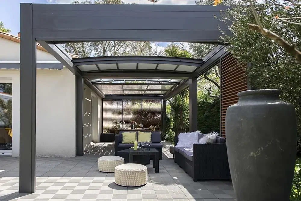 Salon moderne lumineux avec baies vitrées coulissantes aluminium anthracite ouvrant sur terrasse en bois composite et jardin paysagé