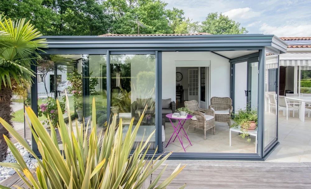 Extension de maison moderne avec véranda fermée à toiture plate, bardage aluminium anthracite RAL 7016